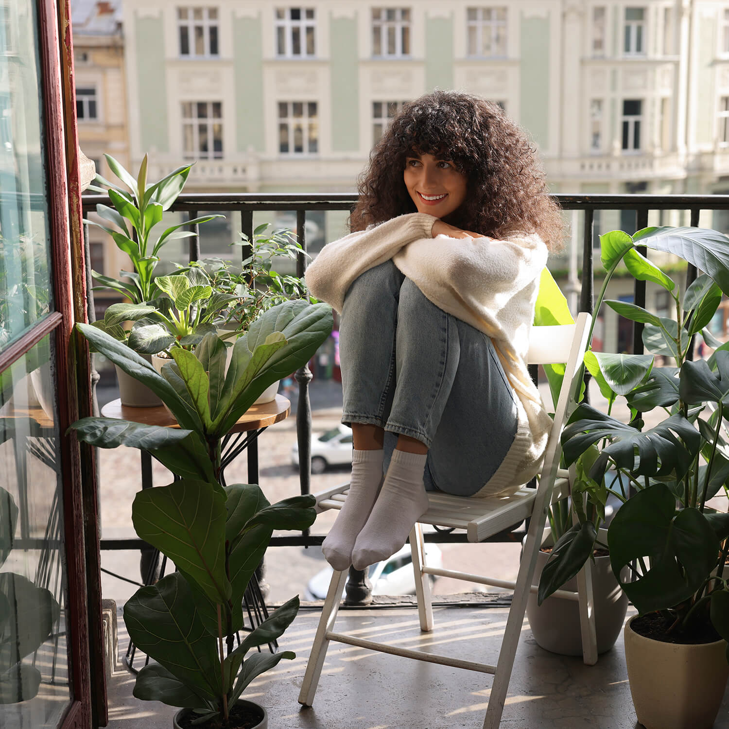Frau in der Stadt genießt auf ihrem Balkon ihre nachhaltige Energie